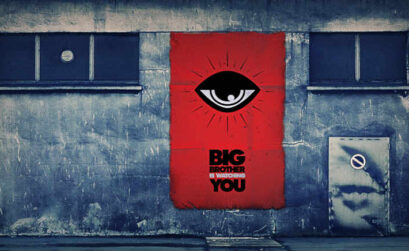 imagen de un muro con un afiche que hace referencia a la frase 'Big Brother is Watching You' de la obra 1984.