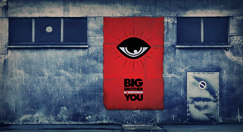 imagen de un muro con un afiche que hace referencia a la frase 'Big Brother is Watching You' de la obra 1984.